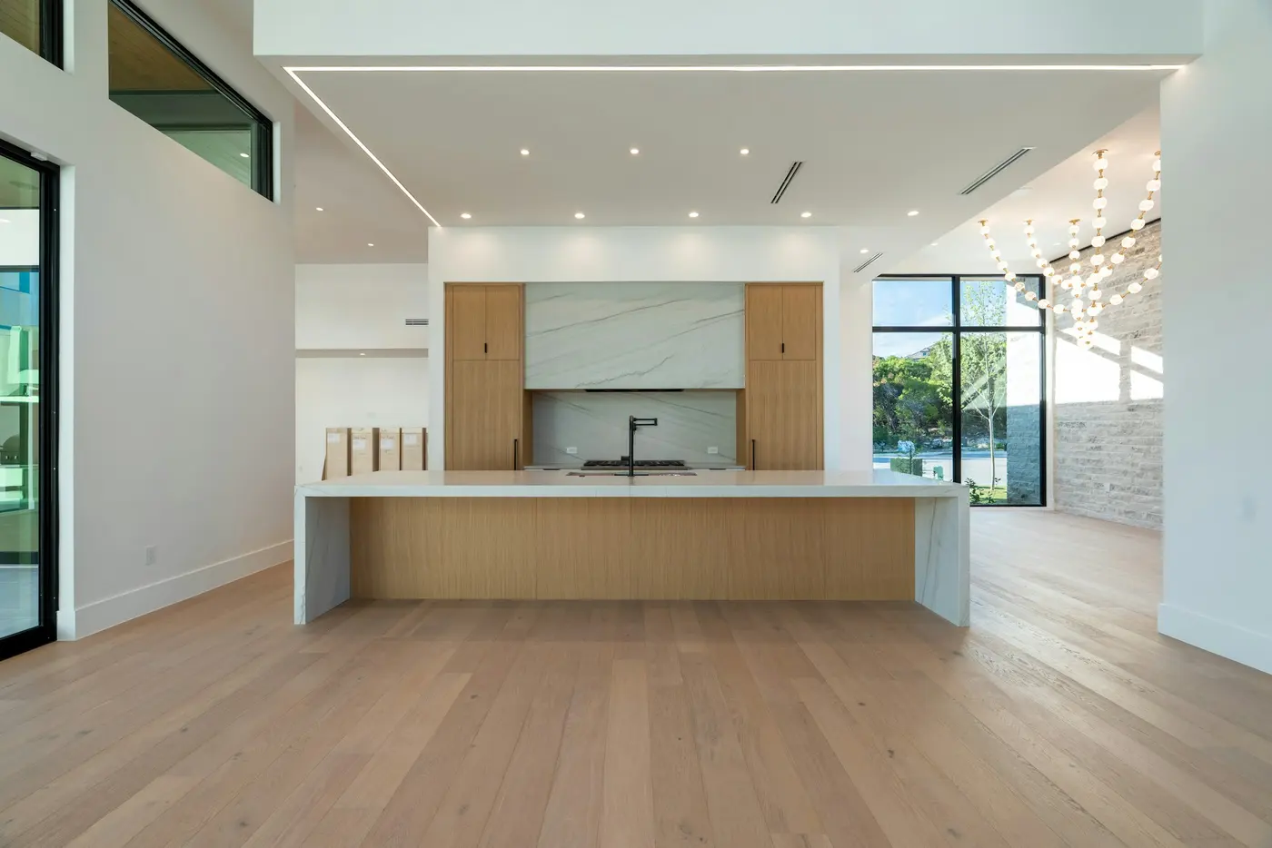 Light white oak plank floor in a modern kitchen with a large island
